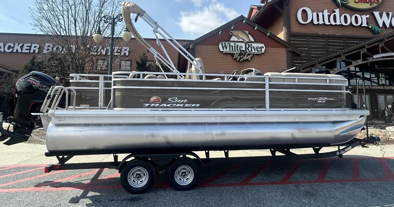 The Image of 2025 Sun Tracker SportFish 22 DLX pontoon boat parked outside Outdoor World. - 0