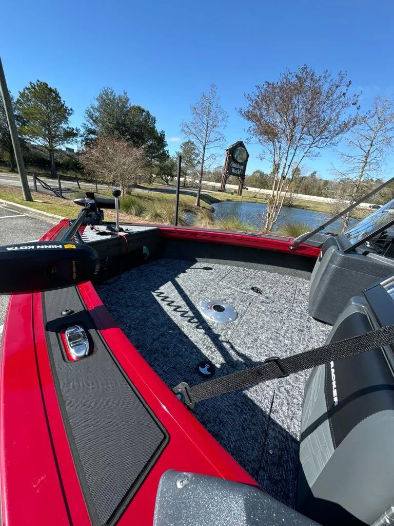 Slide: The Image of 2025 Tracker Targa V-18 WT boat, red exterior, parked near a scenic lake. - 4