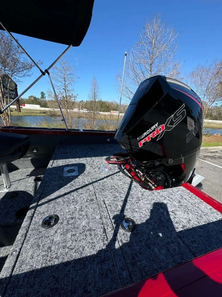 Slide: The Image of 2025 Tracker Targa V-18 WT boat with Mercury Pro XS engine, parked near a lake. - 6