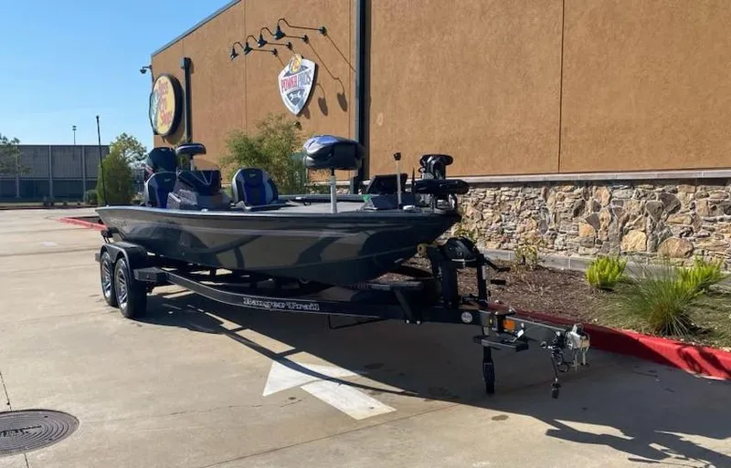 Slide: The Image of 2025 Ranger ALPHA 208 boat on trailer, parked outside a building. - 3