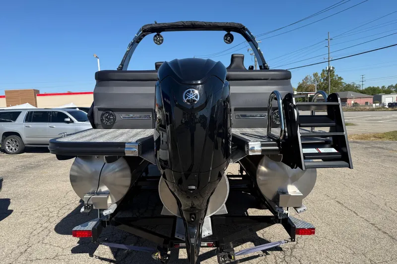 Slide: The Image of 2025 Bennington M Line pontoon boat with Yamaha outboard motor, parked on a trailer. - 2
