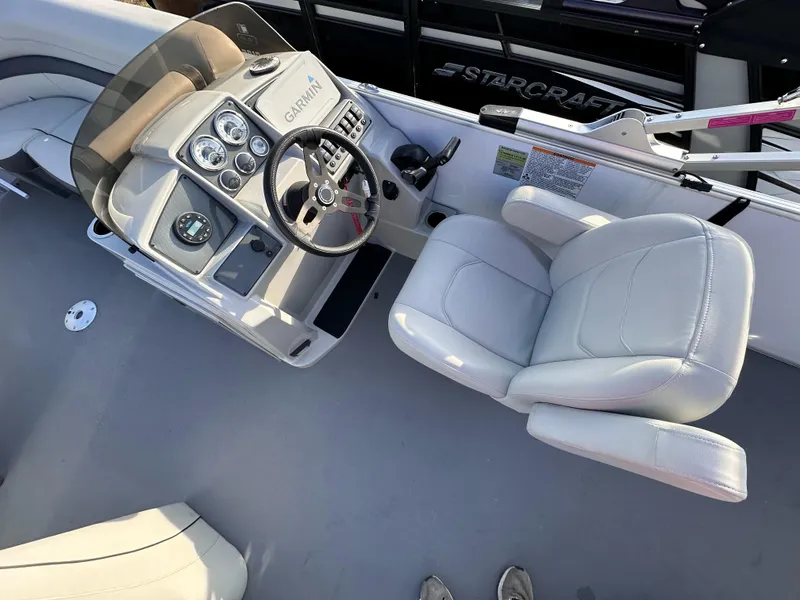 Slide: The Image of 2023 Starcraft EX 20 C boat interior with steering console and captain's chair. - 3