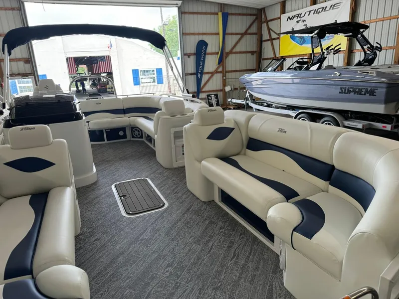 Slide: The Image of 2024 JC Neptoon 23 TT LG pontoon boat interior with plush seating in showroom. - 18