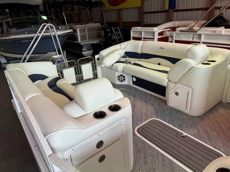 Slide: The Image of 2024 JC Neptoon 23 TT LG pontoon boat interior with white seating in a storage facility. - 6