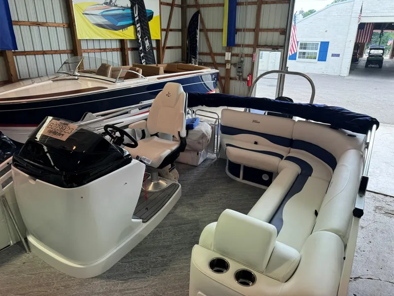 Slide: The Image of 2024 JC Neptoon 23 TT LG pontoon boat with white and blue seating in a showroom. - 7
