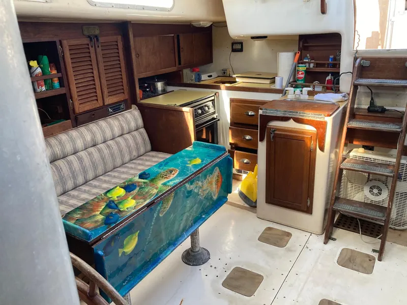 Slide: The Image of 1975 Northstar Hughs Northstar 80/20 Center Cockpit interior with kitchen and seating area. - 12