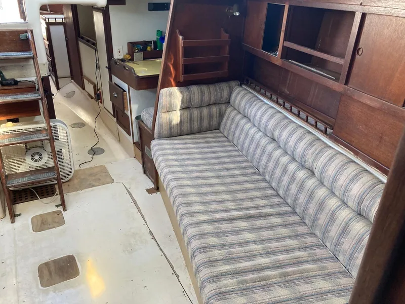 Slide: The Image of 1975 Northstar Hughs Northstar 80/20 Center Cockpit interior with striped sofa and wooden cabinetry. - 13