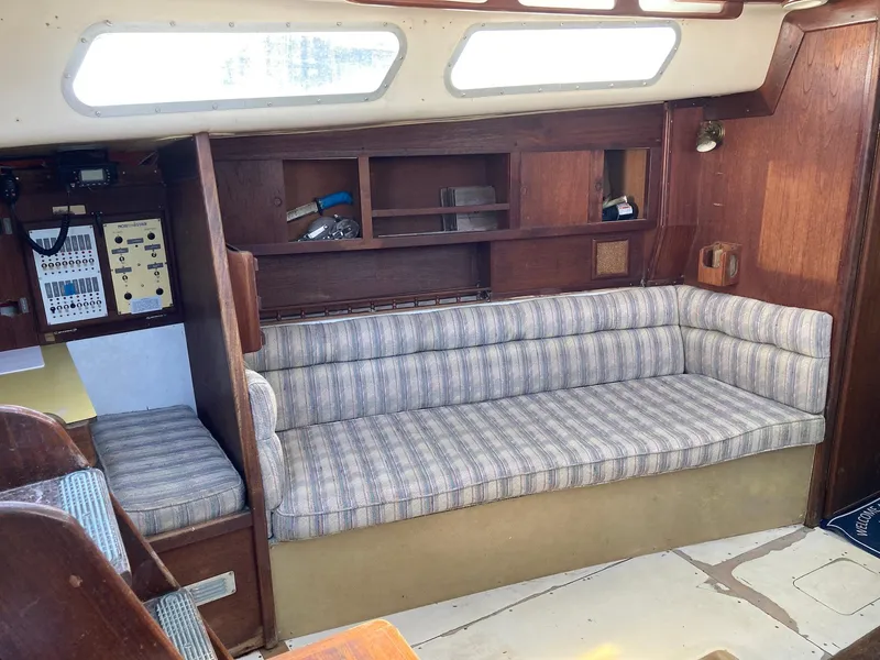 Slide: The Image of 1975 Northstar Hughs Northstar 80/20 Center Cockpit interior with striped sofa and wooden shelves. - 14