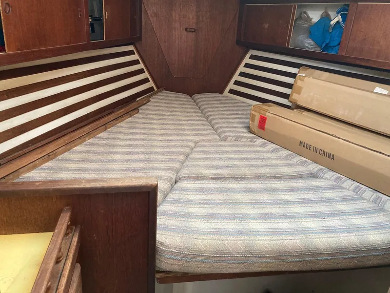 Slide: The Image of 1975 Northstar Hughs Northstar 80/20 cabin interior with striped bedding and wooden cabinetry. - 21