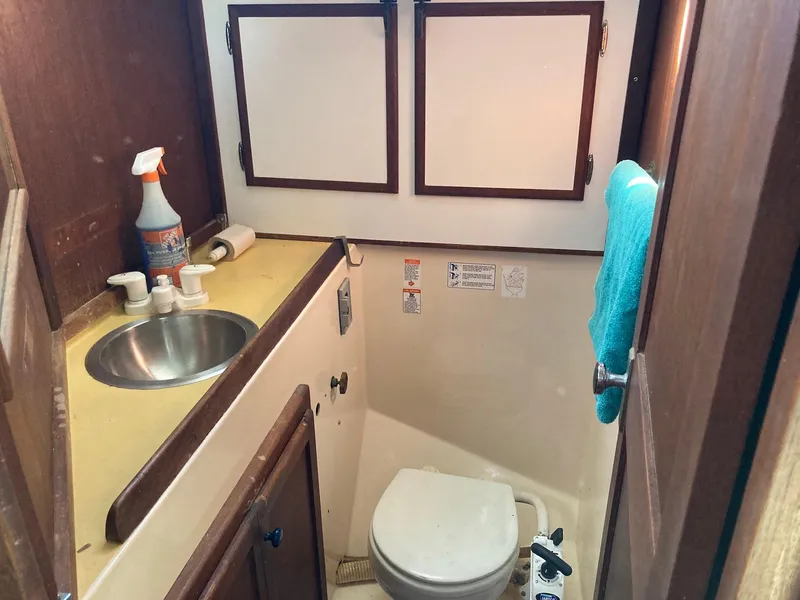 Slide: The Image of 1975 Northstar Hughs Northstar 80/20 Center Cockpit bathroom with sink, toilet, and storage cabinets. - 22