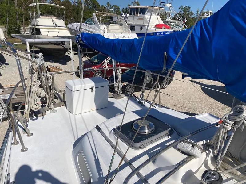 Slide: The Image of 1975 Northstar Hughs 80/20 sailboat with blue sail cover, docked among other boats. - 7