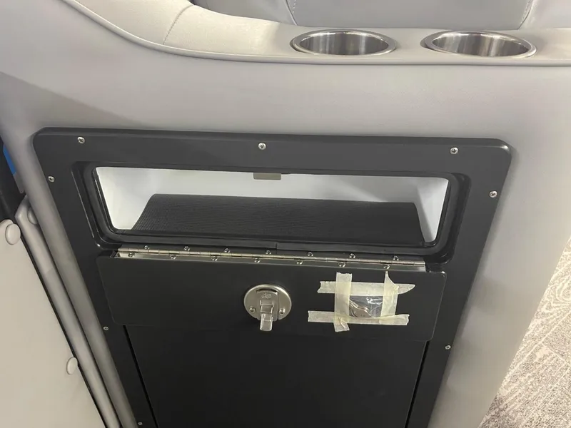 Slide: The Image of 2025 JC Neptoon 23 TT DSL interior with storage compartment and cup holders. - 16