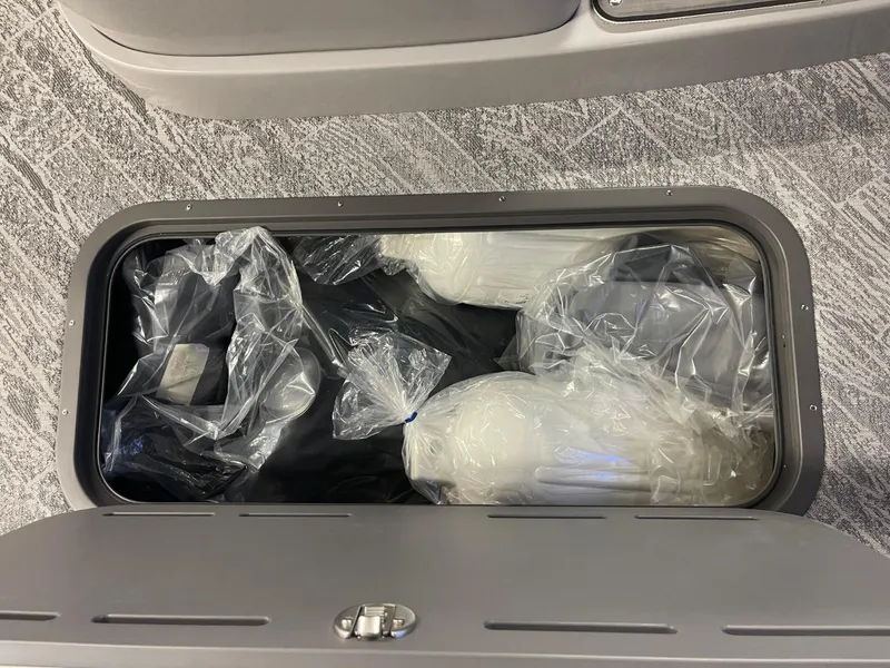 Slide: The Image of Storage compartment of 2025 JC Neptoon 23 TT DSL, containing wrapped items. - 18