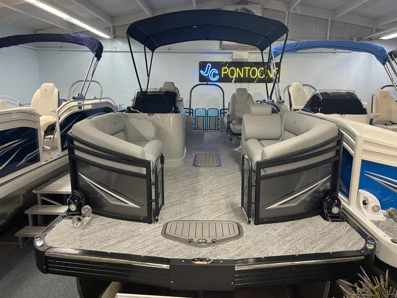 Slide: The Image of 2025 JC Neptoon 23 TT DSL pontoon boat in showroom with seating and canopy. - 3