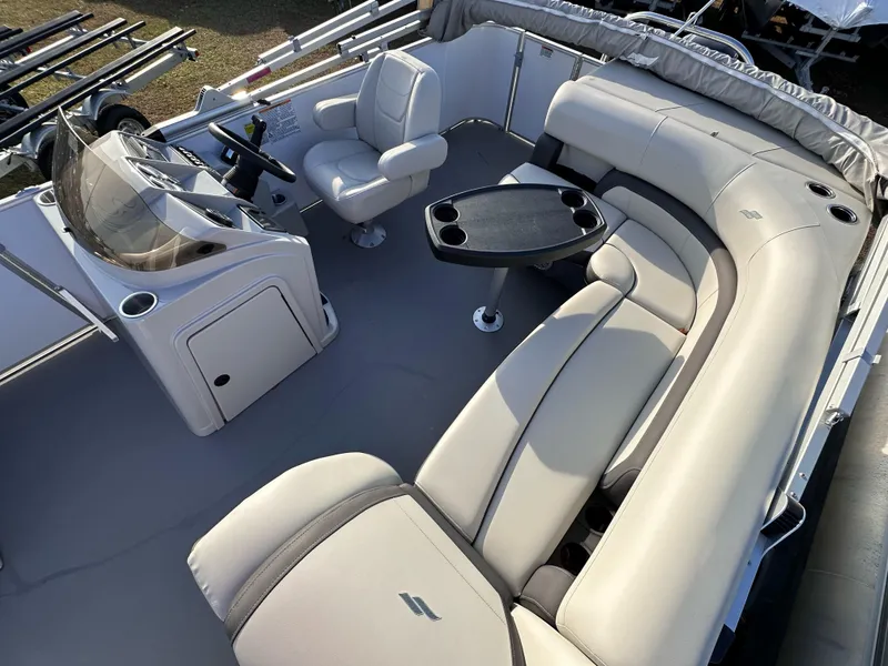 Slide: The Image of 2023 Starcraft EX 22 C SG boat interior with plush seating and steering console. - 2