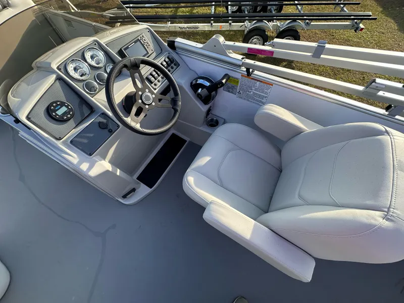 Slide: The Image of 2023 Starcraft EX 22 C SG boat cockpit with steering wheel and control panel. - 3