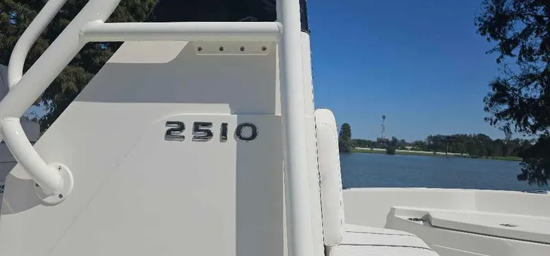 Slide: The Image of 2025 Ranger 2510 Bay boat on a serene lake background. - 2