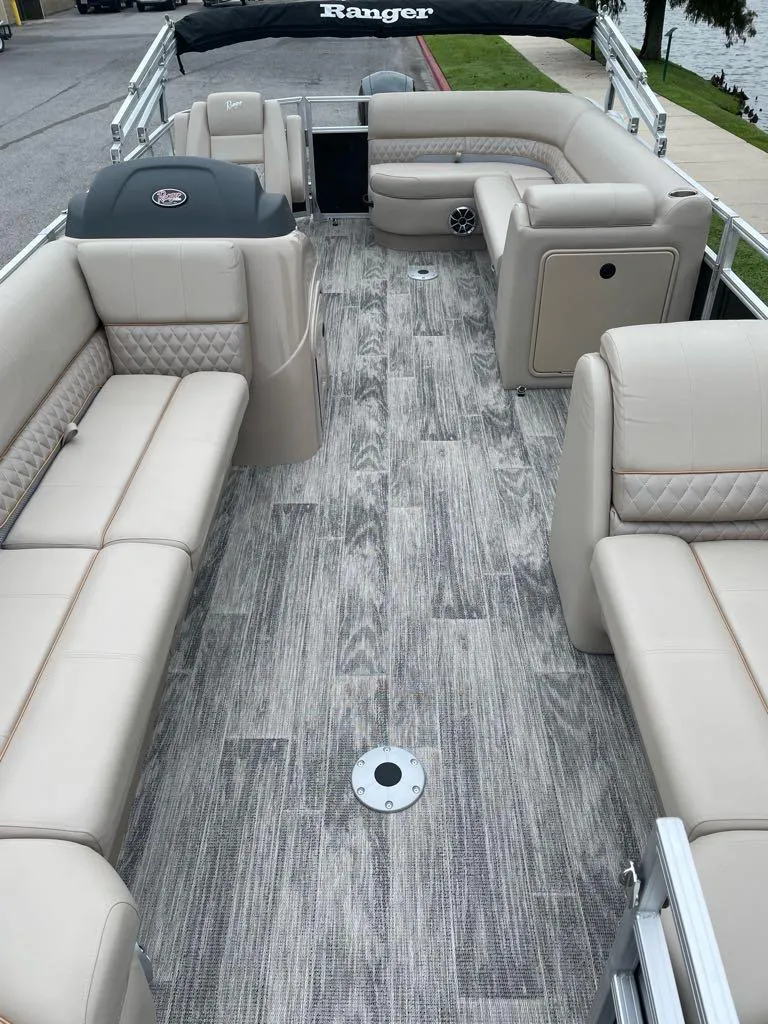 Slide: The Image of 2025 Ranger Reata 220C boat interior with plush seating and wood-style flooring. - 3