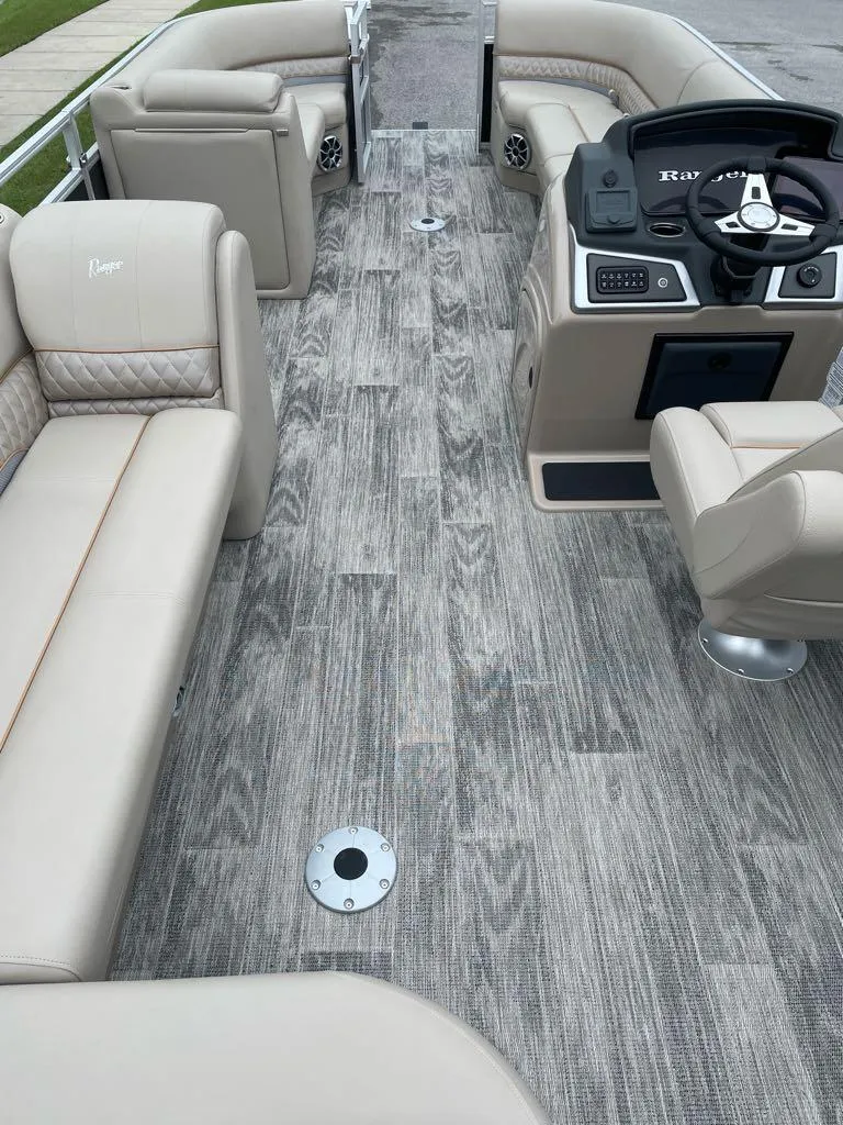 Slide: The Image of 2025 Ranger Reata 220C pontoon boat interior with plush seating and modern helm. - 4