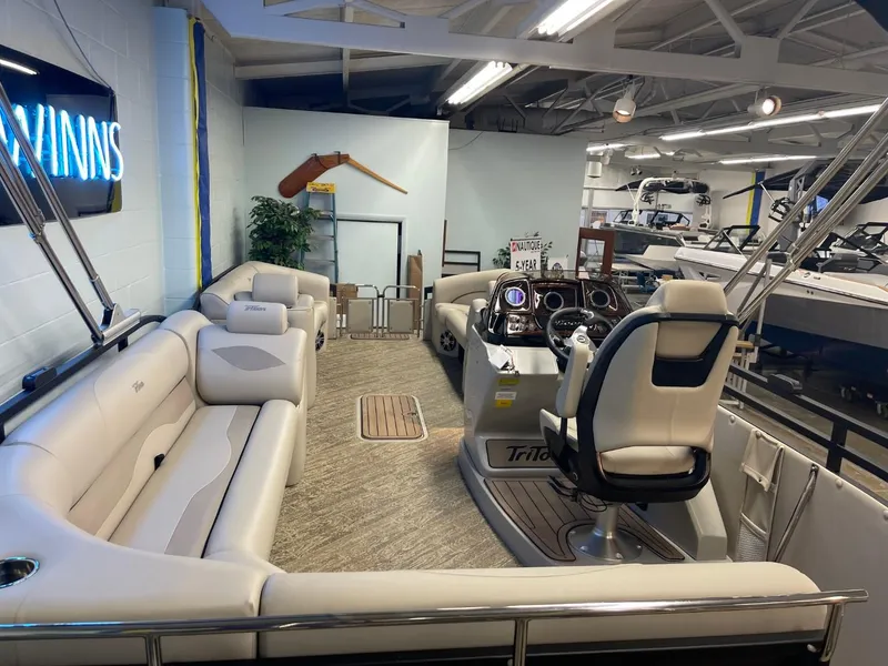 Slide: The Image of 2025 JC Neptoon 23 TT LG pontoon boat interior with plush seating and modern helm. - 13