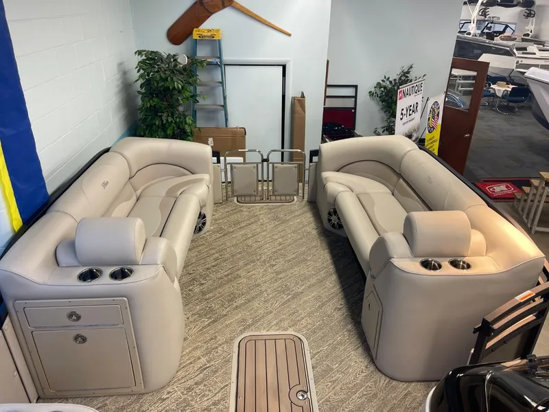 Slide: The Image of 2025 JC Neptoon 23 TT LG pontoon boat interior with beige seating and cup holders. - 16