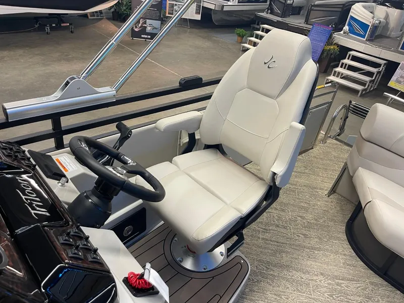 Slide: The Image of 2025 JC Neptoon 23 TT LG boat interior with captain's chair and steering wheel. - 30