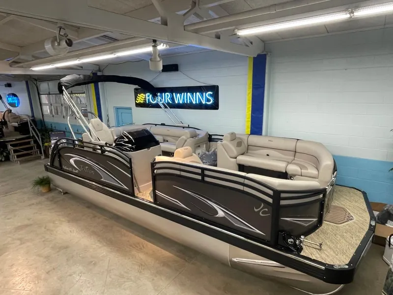 Slide: The Image of 2025 JC Neptoon 23 TT LG pontoon boat in showroom with seating and canopy. - 5