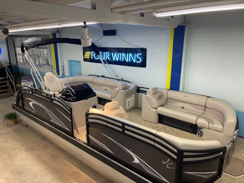 Slide: The Image of 2025 JC Neptoon 23 TT LG pontoon boat in showroom with Four Winns sign. - 6