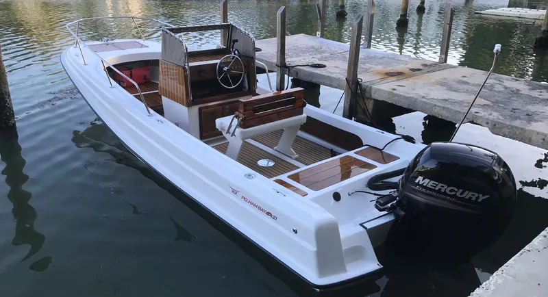 Slide: The Image of 2025 Metan Pelham Bay 21 boat docked with Mercury outboard motor. - 2