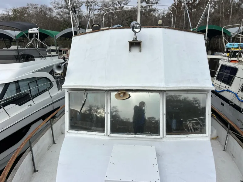 Slide: The Image of 1972 Grand Banks 42 Classic boat docked, front view with reflection in windows. - 12