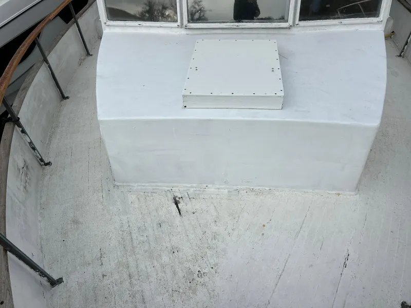 Slide: The Image of 1972 Grand Banks 42 Classic boat deck with white surface and railing. - 14