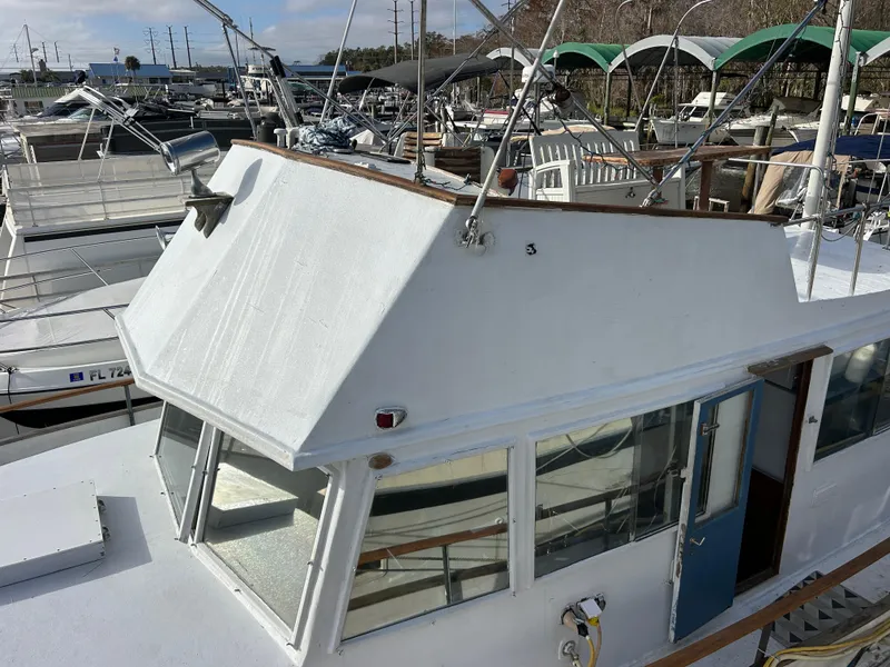 Slide: The Image of 1972 Grand Banks 42 Classic yacht docked at marina, showcasing upper deck and cabin. - 15