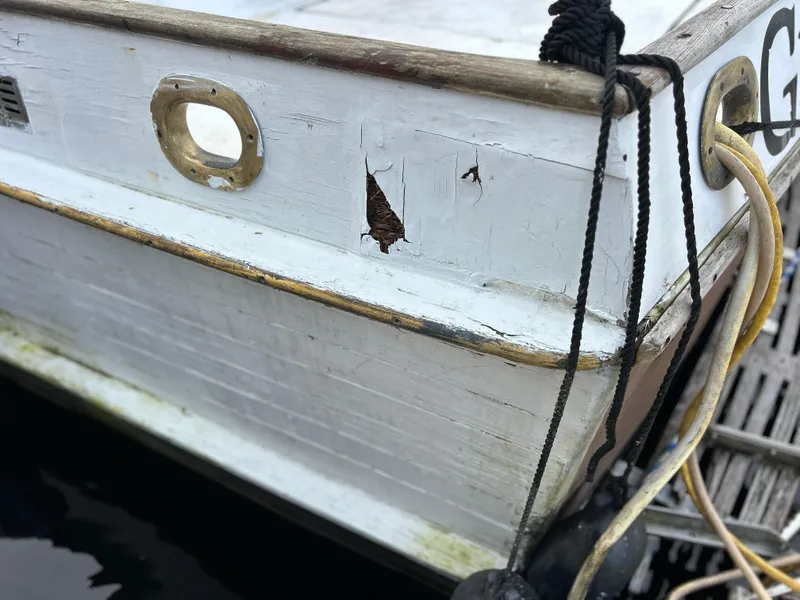 Slide: The Image of Close-up of 1972 Grand Banks 42 Classic boat with visible hull damage. - 18