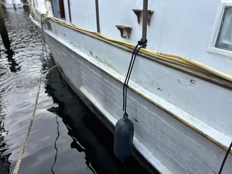 Slide: The Image of 1972 Grand Banks 42 Classic boat with fender, docked in calm water. - 19