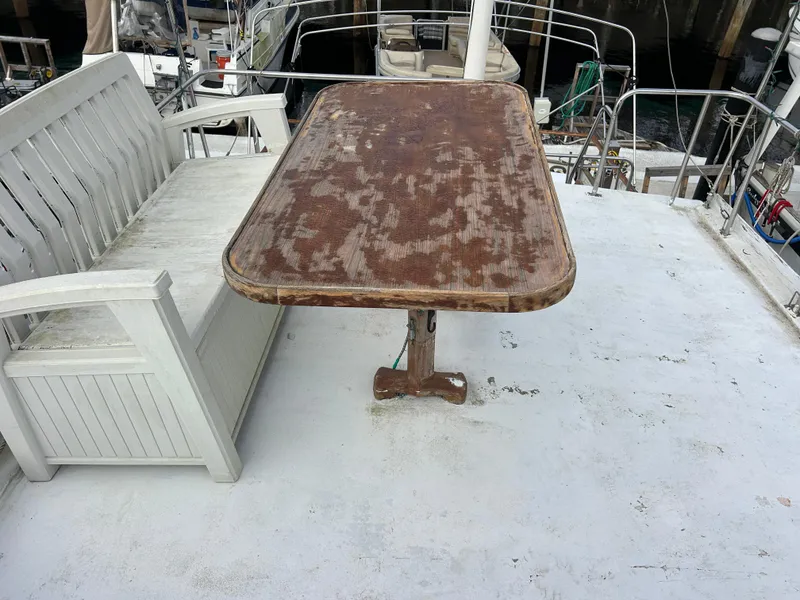 Slide: The Image of Weathered deck of 1972 Grand Banks 42 Classic with rustic table and bench seating. - 26