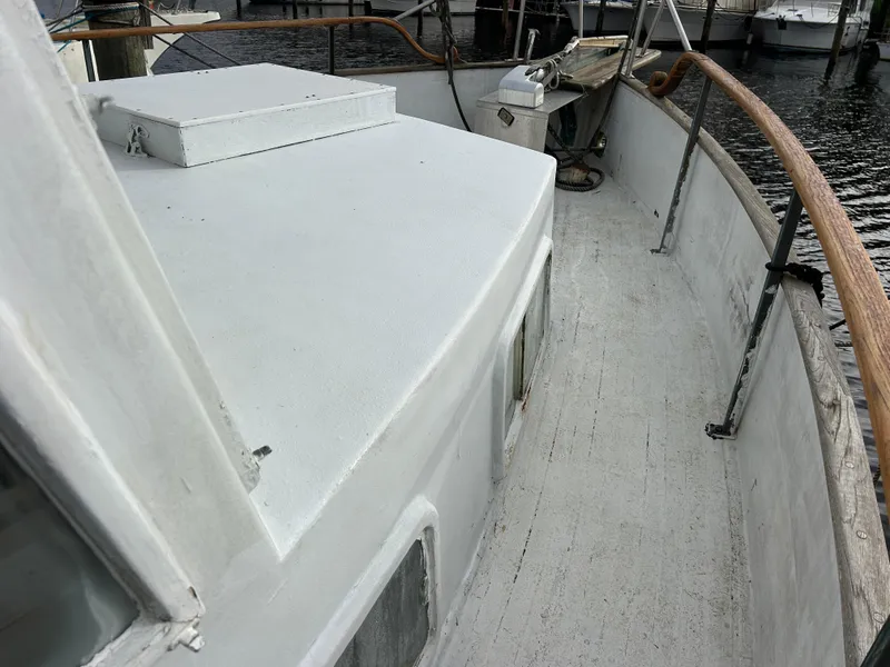 Slide: The Image of 1972 Grand Banks 42 Classic yacht deck with wooden railings and white surface. - 31