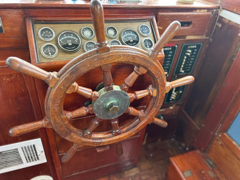 Slide: The Image of Wooden helm of a 1972 Grand Banks 42 Classic boat with vintage gauges. - 42