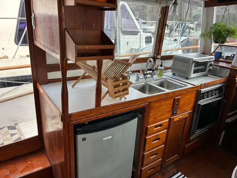 Slide: The Image of 1972 Grand Banks 42 Classic yacht kitchen with wood cabinetry and modern appliances. - 48