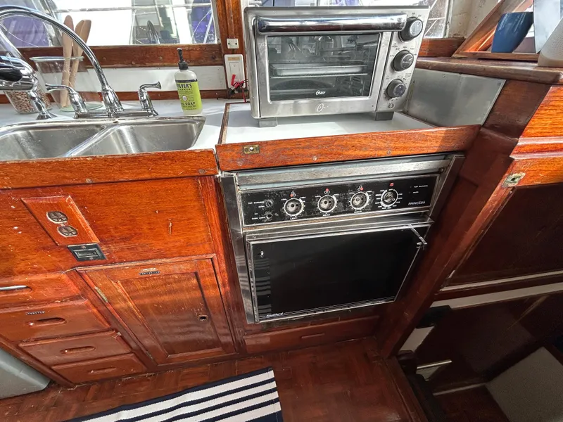 Slide: The Image of Vintage 1972 Grand Banks 42 Classic yacht kitchen with wood cabinetry and modern appliances. - 49