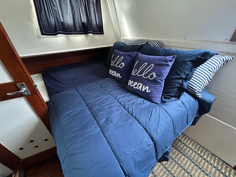 Slide: The Image of Cozy cabin bedroom in 1972 Grand Banks 42 Classic yacht with nautical-themed pillows. - 54