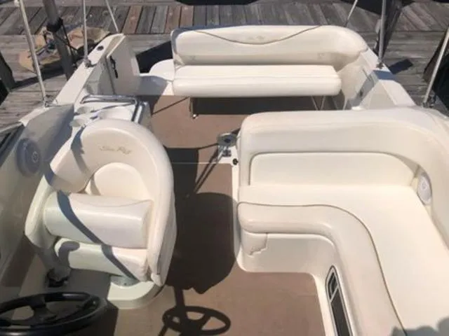 Slide: The Image of 2003 Sea Ray 260 Sundancer boat interior with white seating and steering wheel. - 12