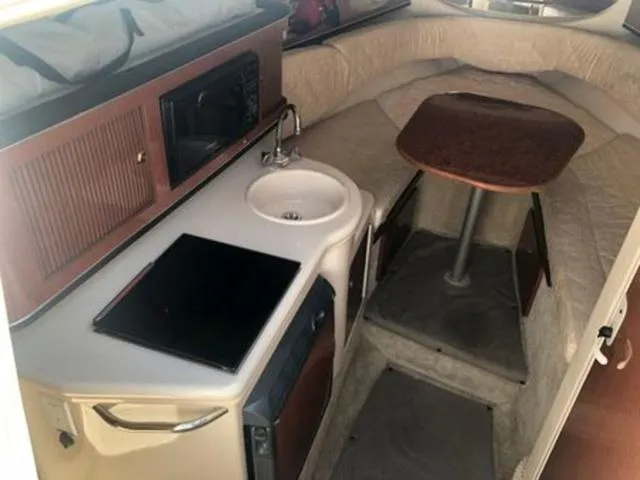 Slide: The Image of Interior of 2003 Sea Ray 260 Sundancer with kitchenette and seating area. - 15