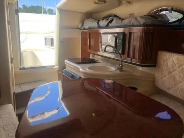 Slide: The Image of Interior of 2003 Sea Ray 260 Sundancer boat with kitchenette and seating area. - 17
