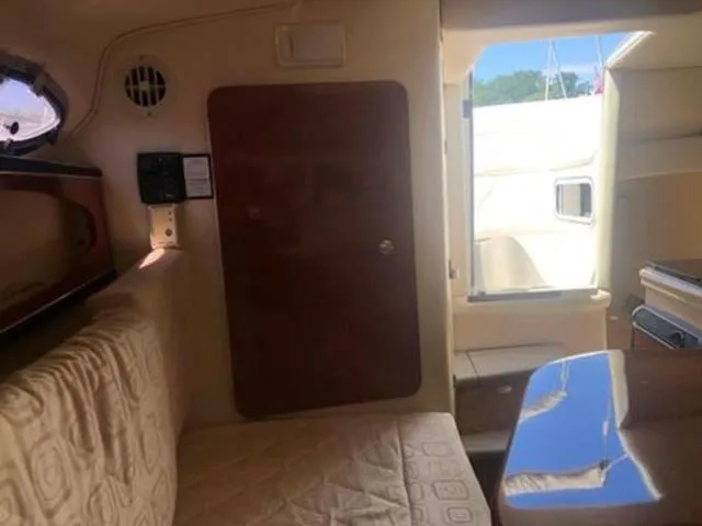 Slide: The Image of Interior of 2003 Sea Ray 260 Sundancer boat, featuring seating and a wooden door. - 18