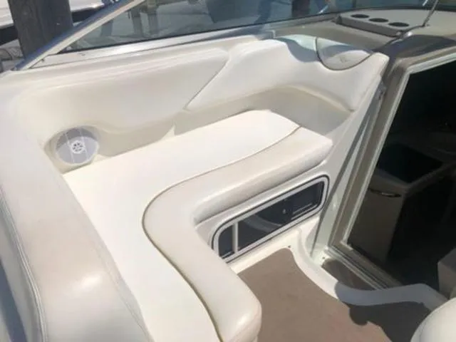 Slide: The Image of 2003 Sea Ray 260 Sundancer boat interior with white seating and speaker. - 9