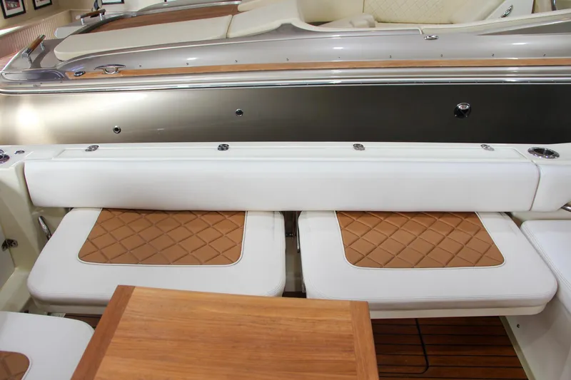 Slide: The Image of 2019 Chris-Craft Calypso 30 interior with white seating and wooden accents. - 11