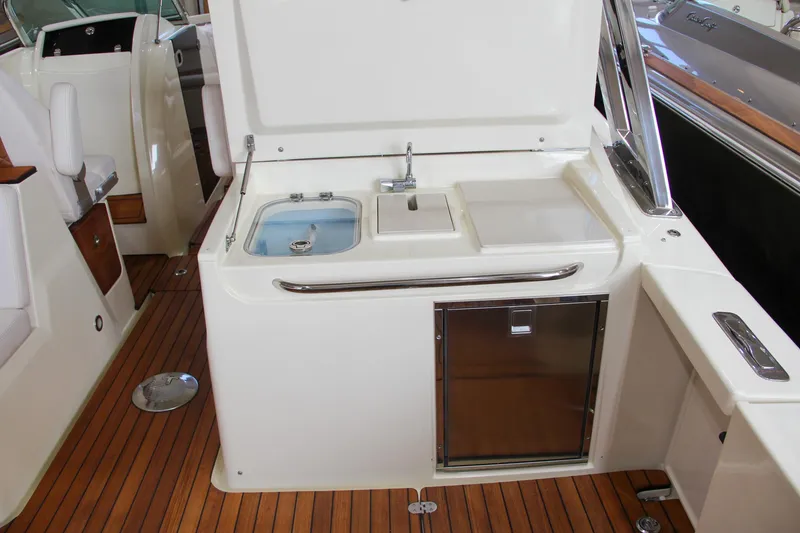 Slide: The Image of 2019 Chris-Craft Calypso 30 boat interior with sink and storage on teak deck. - 13