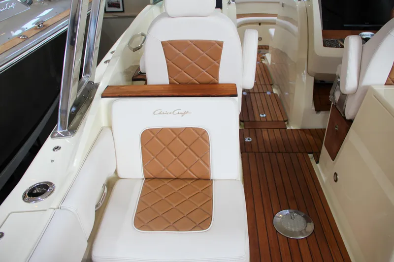 Slide: The Image of 2019 Chris-Craft Calypso 30 interior with tan leather seats and wooden flooring. - 14