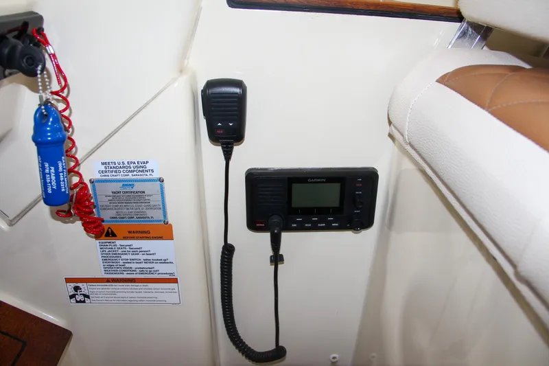 Slide: The Image of 2019 Chris-Craft Calypso 30 boat interior with radio and safety instructions. - 20
