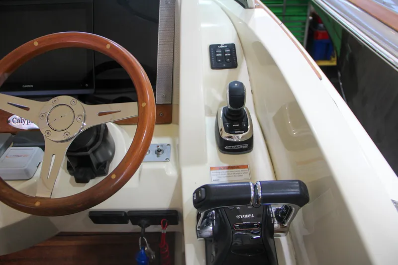 Slide: The Image of 2019 Chris-Craft Calypso 30 helm with wooden steering wheel and Yamaha controls. - 21
